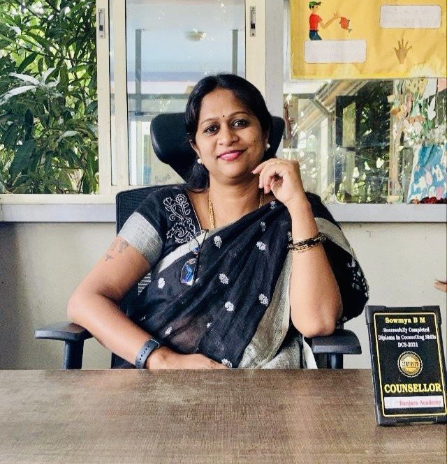 Sowmya Basvaraj, founder and counsellor at Solace Minds, smiling at her desk
