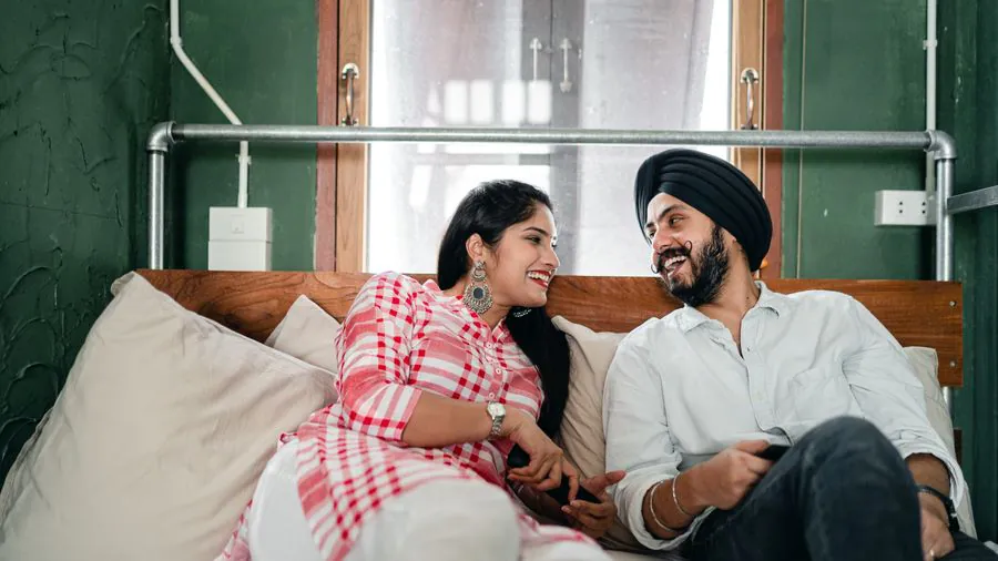 An Indian couple talking and laughing in their living room