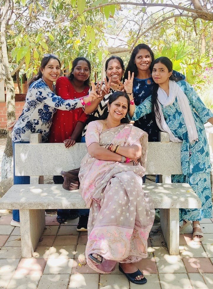 Mrs. Sowmya Basvaraj smiling with a group of women on a garden bench